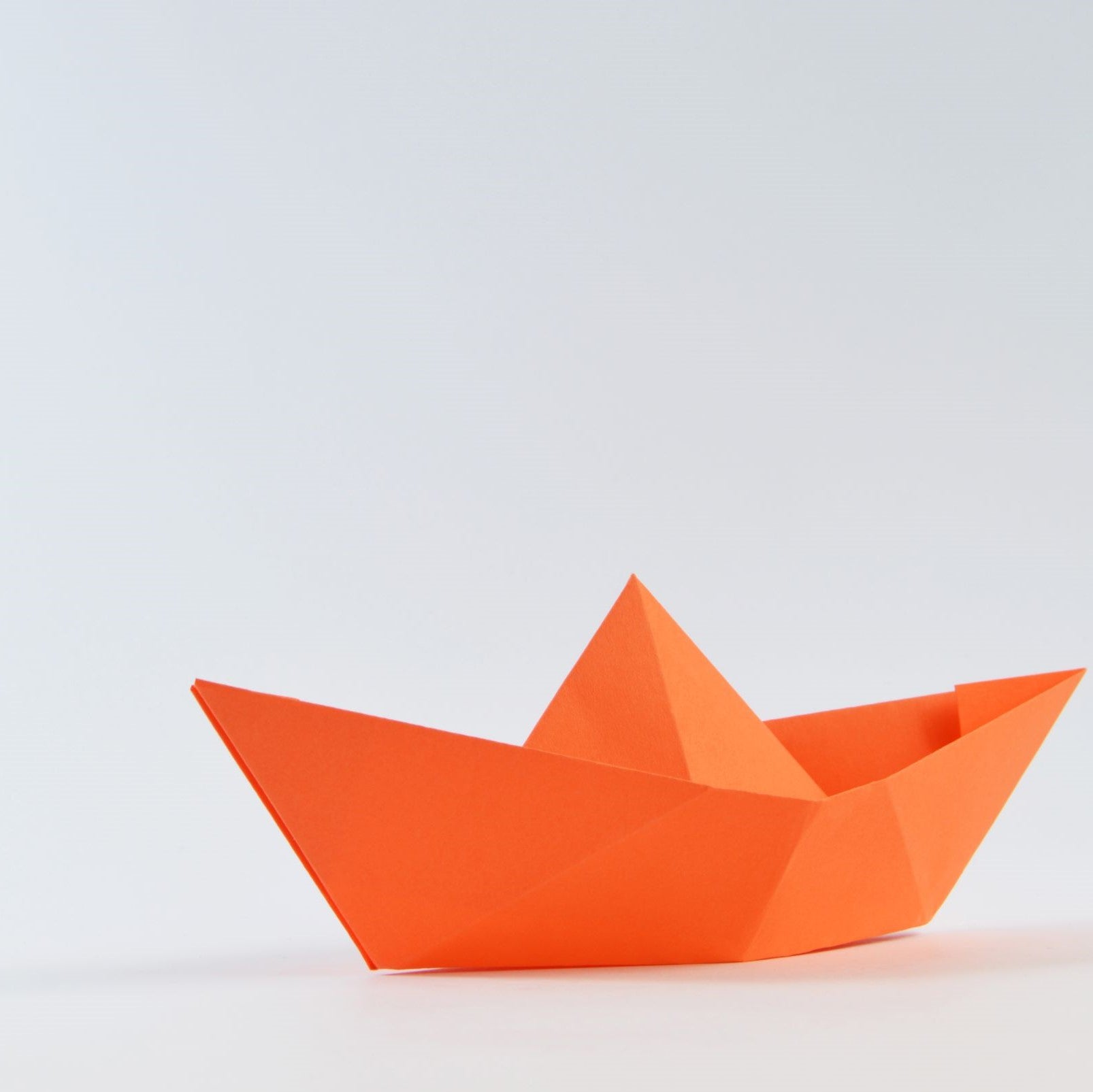 Orange origami sailboat - Photo by Miguel Á. Padriñán