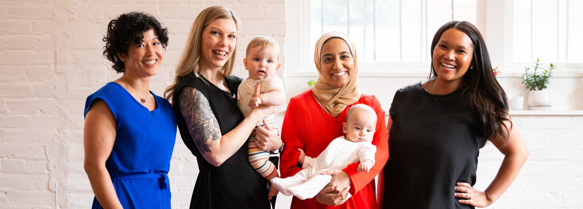 Four moms modeling pumping and nursing clothing and holding babies